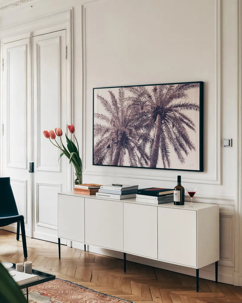 Pink Palms Horizontal by Deborah Revell. shown as a framed stretched canvas in a living room above a console. Available as a archival giclee rolled canvas, fine art paper, or poster print. SKU 94378i.