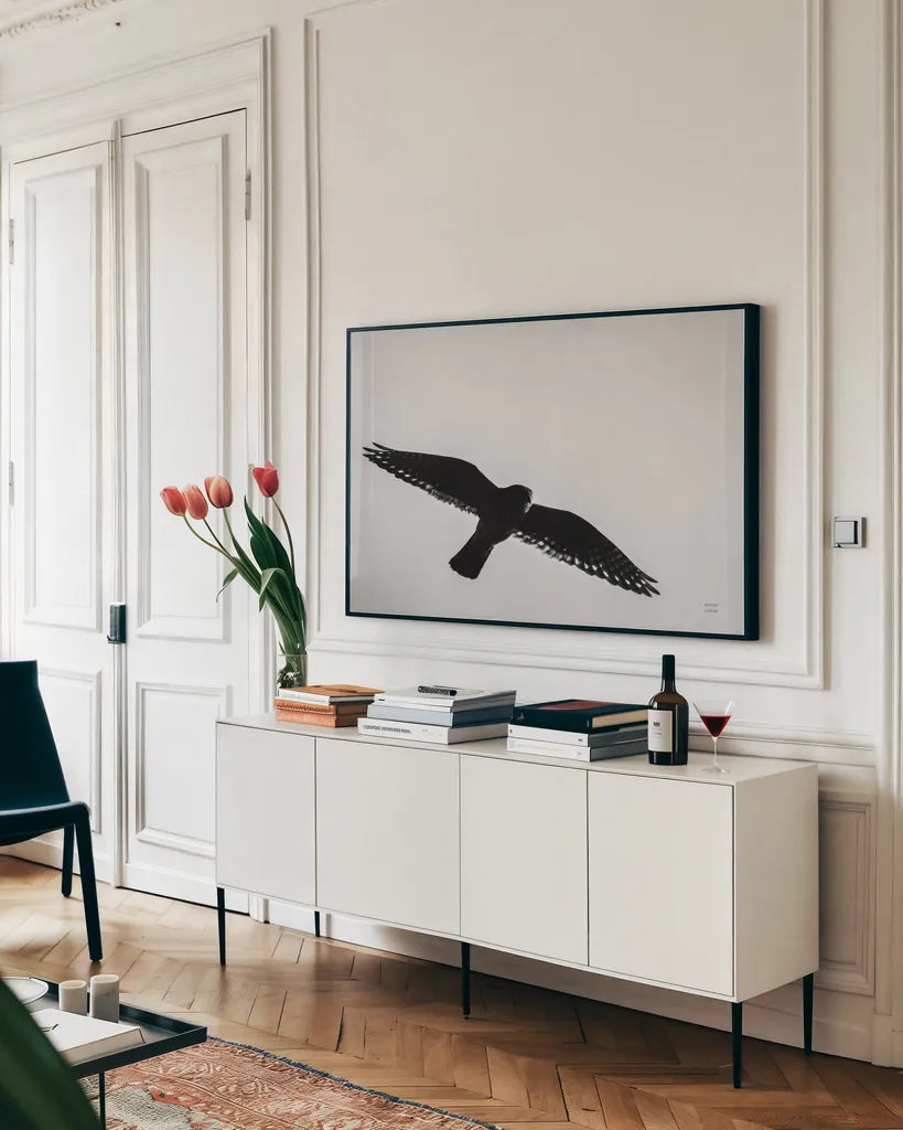 American Kestrel Hunting by Nathan Larson. shown as a framed stretched canvas in a living room above a console. Available as a archival giclee rolled canvas, fine art paper, or poster print. SKU 92577i.