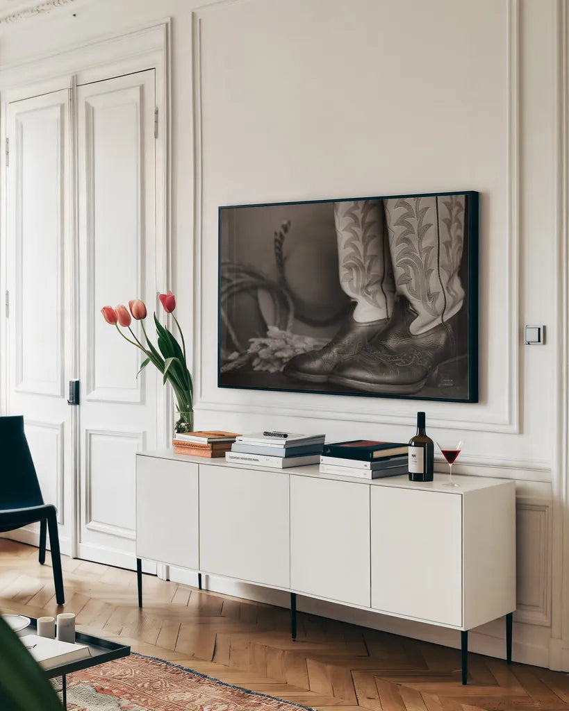 Cowboy Boots XI BW by Nathan Larson. shown as a framed stretched canvas in a living room above a console. Available as a archival giclee rolled canvas, fine art paper, or poster print. SKU 82741i.