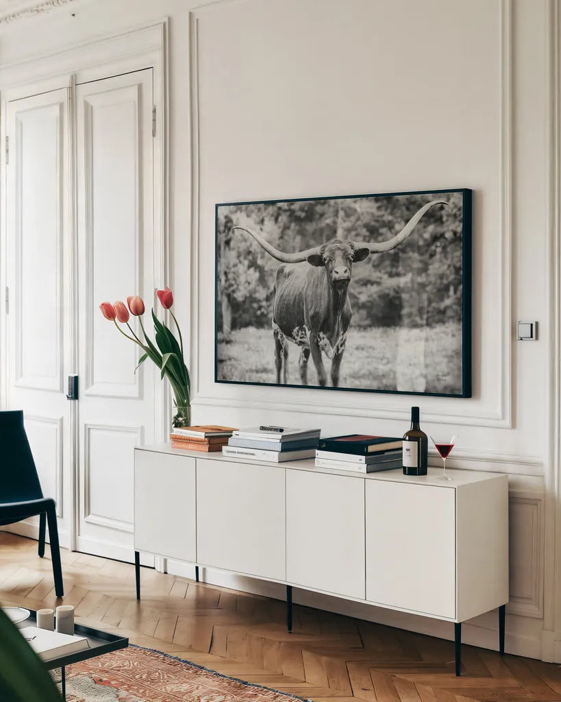 Longhorn Nosing Around by Nathan Larson. shown as a framed stretched canvas in a living room above a console. Available as a archival giclee rolled canvas, fine art paper, or poster print. SKU 93358i.