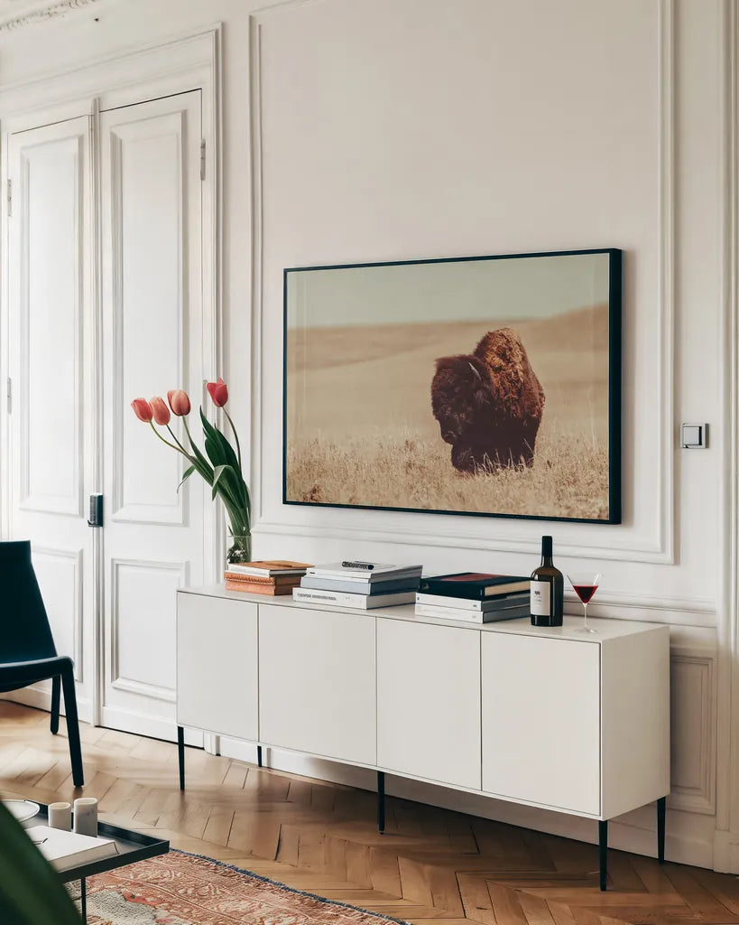 Tall Grass Bison I by Nathan Larson. shown as a framed stretched canvas in a living room above a console. Available as a archival giclee rolled canvas, fine art paper, or poster print. SKU 86065i.