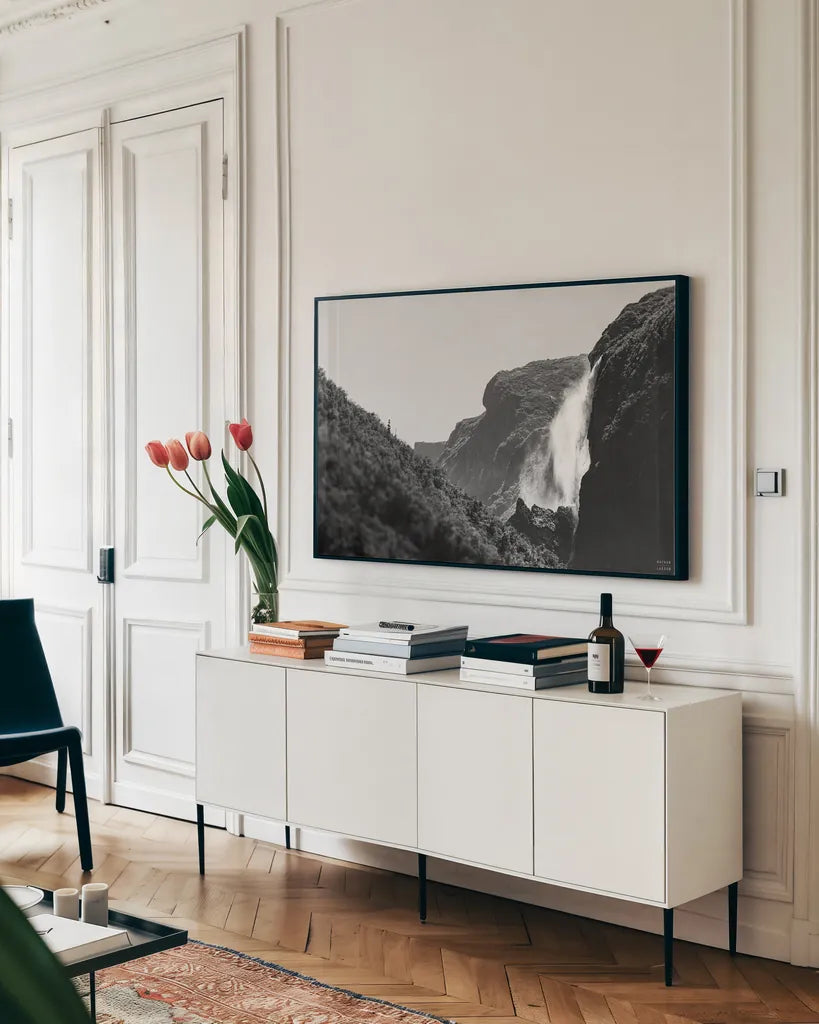 Western Brook Pond Falls BW by Nathan Larson. shown as a framed stretched canvas in a living room above a console. Available as a archival giclee rolled canvas, fine art paper, or poster print. SKU 101659i.