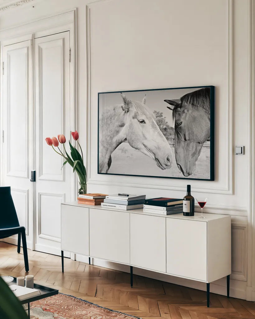 Two Horses BW by Sharon Vardy. shown as a framed stretched canvas in a living room above a console. Available as a archival giclee rolled canvas, fine art paper, or poster print. SKU 92185i.