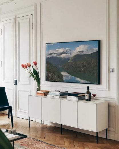 Diablo Lake and Colonial Peak by Alan Majchrowicz. shown as a framed stretched canvas in a living room above a console. Available as a archival giclee rolled canvas, fine art paper, or poster print. SKU 101145i.