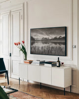 Little Redfish Lakeshore by Alan Majchrowicz. shown as a framed stretched canvas in a living room above a console. Available as a archival giclee rolled canvas, fine art paper, or poster print. SKU 64558i.
