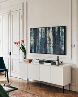 Deep Woods III Indigo by Albena Hristova. shown as a framed stretched canvas in a living room above a console. Available as a archival giclee rolled canvas, fine art paper, or poster print. SKU 36319i.