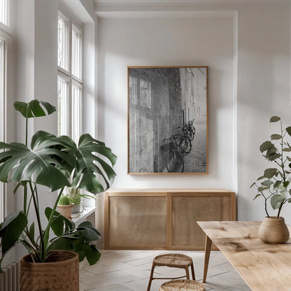 Bicycles in the Alley by Aledanda. shown as a print in a natural wood frame in a dining room. Available as a archival giclee rolled canvas, fine art paper, or poster print. SKU 67688h.