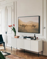 Camels on the Move by Aledanda. shown as a framed stretched canvas in a living room above a console. Available as a archival giclee rolled canvas, fine art paper, or poster print. SKU 63224i.