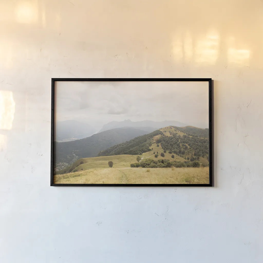 Grassy Hills and Mountains by Aledanda. shown as a paper print in a black flame. Available as a archival giclee rolled canvas, fine art paper, or poster print. SKU 63229i.