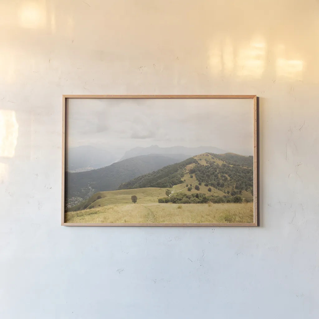 Grassy Hills and Mountains by Aledanda. shown as a paper print in a natural frame. Available as a archival giclee rolled canvas, fine art paper, or poster print. SKU 63229i.