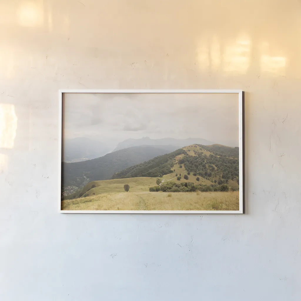 Grassy Hills and Mountains by Aledanda. shown as a paper print in a white frame. Available as a archival giclee rolled canvas, fine art paper, or poster print. SKU 63229i.
