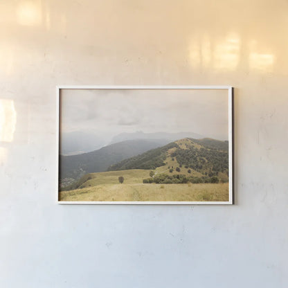 Grassy Hills and Mountains by Aledanda. shown as a paper print in a white frame. Available as a archival giclee rolled canvas, fine art paper, or poster print. SKU 63229i.