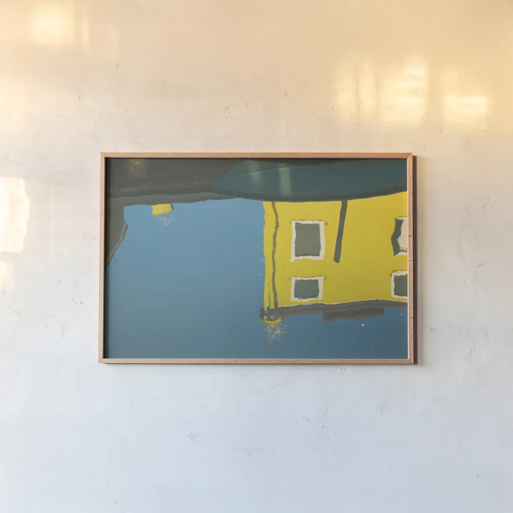 Reflections of Burano VIII by Aledanda. shown as a paper print in a natural frame. Available as a archival giclee rolled canvas, fine art paper, or poster print. SKU 41601i.