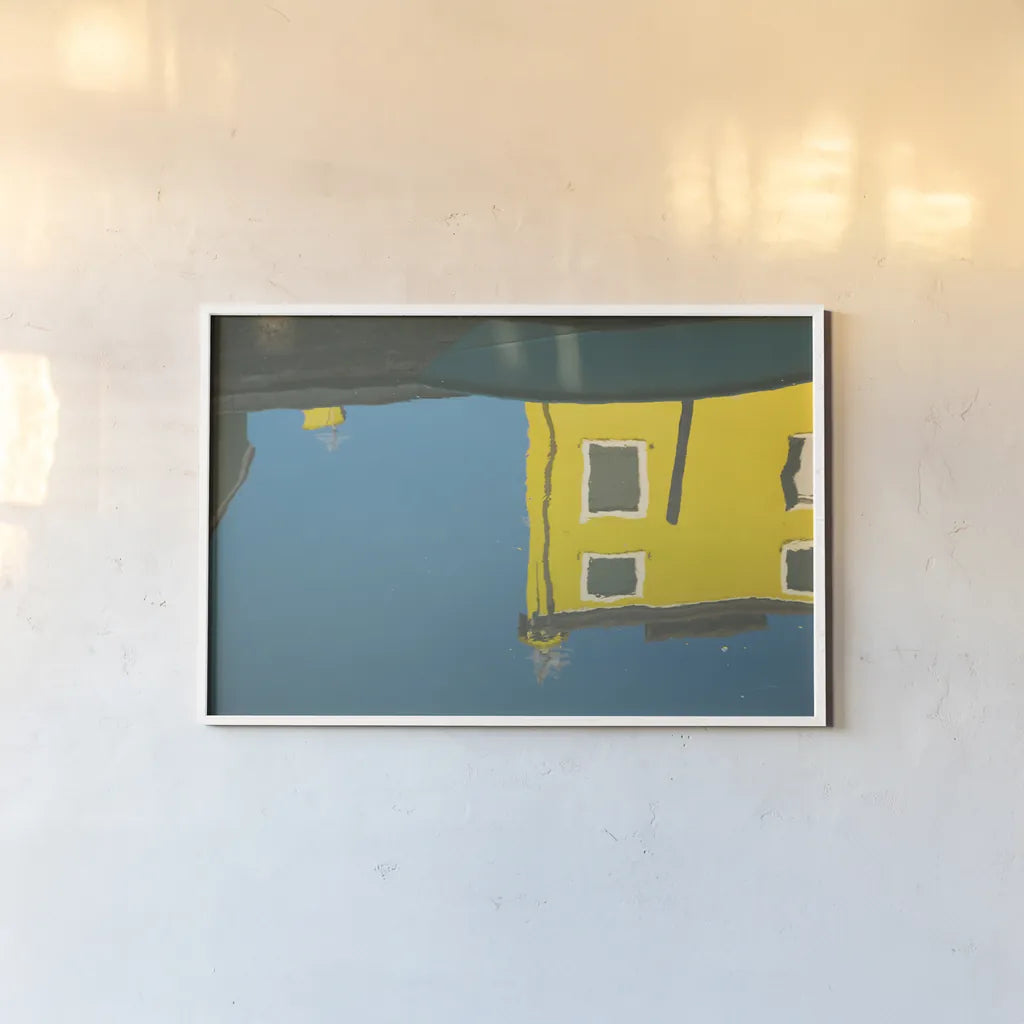 Reflections of Burano VIII by Aledanda. shown as a paper print in a white frame. Available as a archival giclee rolled canvas, fine art paper, or poster print. SKU 41601i.