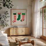 Three Stockings by Ann Kelle. Shown in a natural wood frame in a cozy modern living room. Available as an archival giclee rolled canvas, fine art paper, or poster print. SKU 81237a.