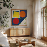 Geo Bright Primary by Avery Tillmon. Shown in a natural wood frame in a cozy modern living room. Available as an archival giclee rolled canvas, fine art paper, or poster print. SKU 82313a.