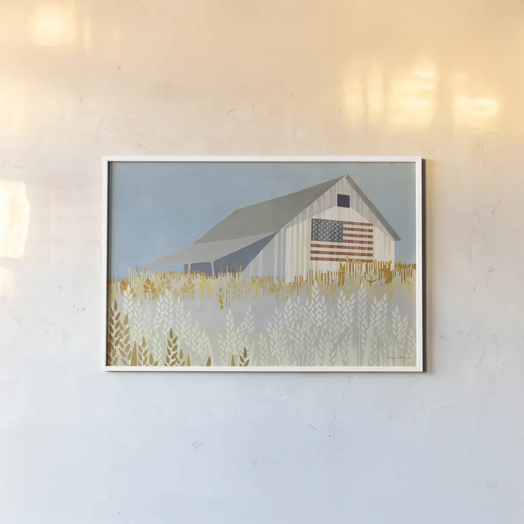 Wheat Fields Barn with Flag by Avery Tillmon. shown as a paper print in a white frame. Available as a archival giclee rolled canvas, fine art paper, or poster print. SKU 76408i.