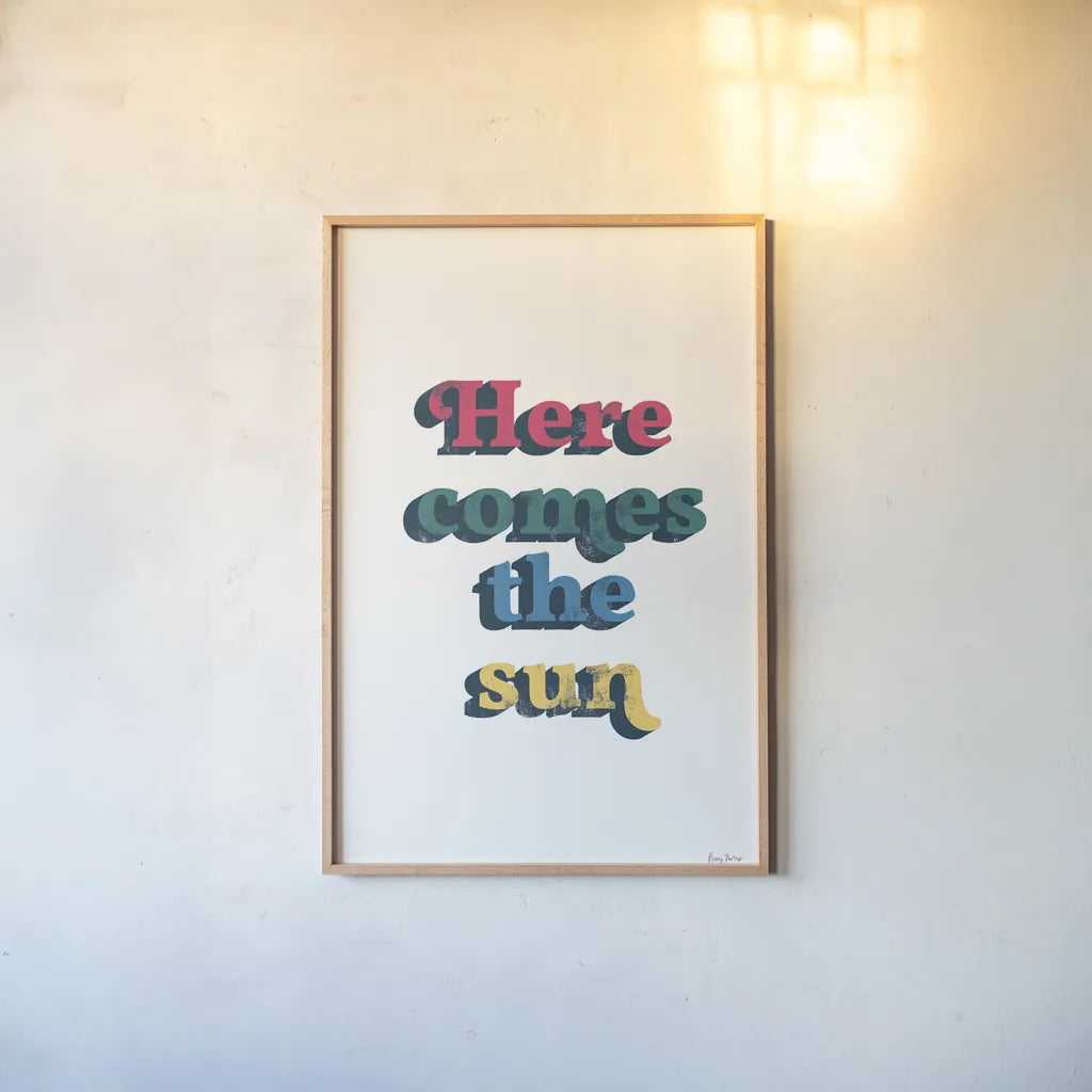 Rainbow Here Comes the Sun Bold by Becky Thorns. shown as a paper print in a natural frame. Available as a archival giclee rolled canvas, fine art paper, or poster print. SKU 65214h.