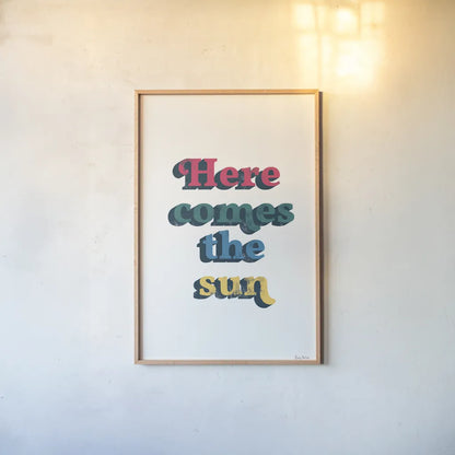 Rainbow Here Comes the Sun Bold by Becky Thorns. shown as a paper print in a natural frame. Available as a archival giclee rolled canvas, fine art paper, or poster print. SKU 65214h.