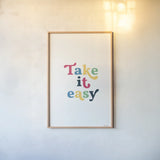 Rainbow Take it Easy by Becky Thorns. shown as a paper print in a natural frame. Available as a archival giclee rolled canvas, fine art paper, or poster print. SKU 65208h.