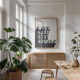 Work Hard Stay Humble BW by Becky Thorns. shown as a print in a natural wood frame in a dining room. Available as a archival giclee rolled canvas, fine art paper, or poster print. SKU 59634h.