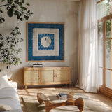 Sea Shell on Blue I by Belinda Aldrich. Shown in a natural wood frame in a cozy modern living room. Available as an archival giclee rolled canvas, fine art paper, or poster print. SKU 11933a.