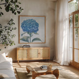 Blue Hydrangea III Light by Beth Grove. Shown in a natural wood frame in a cozy modern living room. Available as an archival giclee rolled canvas, fine art paper, or poster print. SKU 21476a.