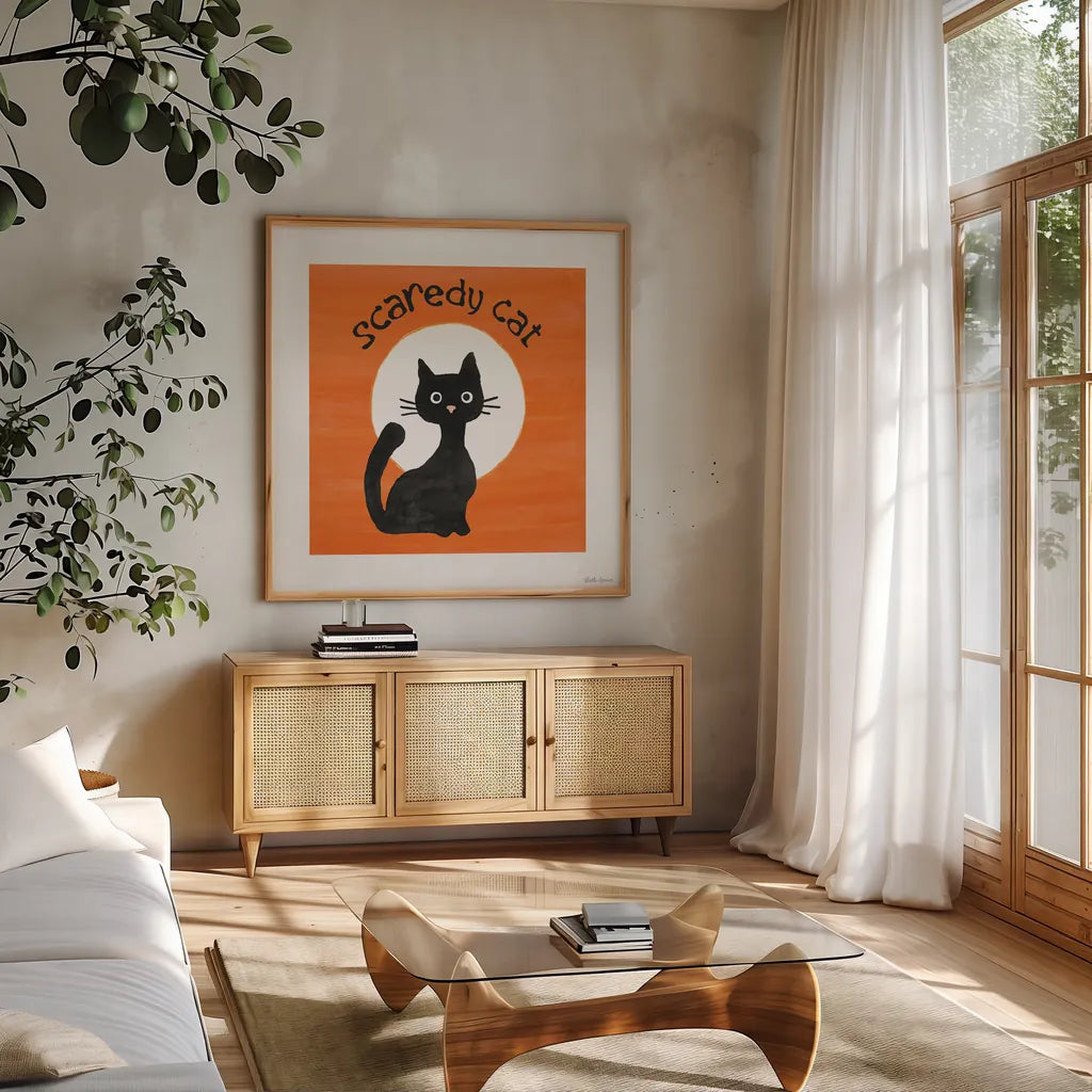 Scaredy Cat Orange by Beth Grove. Shown in a natural wood frame in a cozy modern living room. Available as an archival giclee rolled canvas, fine art paper, or poster print. SKU 95254a.