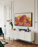 Bountiful Gerberas by Carol Rowan. shown as a framed stretched canvas in a living room above a console. Available as a archival giclee rolled canvas, fine art paper, or poster print. SKU 10879i.