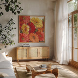Bountiful Gerberas Square II by Carol Rowan. Shown in a natural wood frame in a cozy modern living room. Available as an archival giclee rolled canvas, fine art paper, or poster print. SKU 26992a.