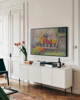 Garden Wheelbarrow by Carol Rowan. shown as a framed stretched canvas in a living room above a console. Available as a archival giclee rolled canvas, fine art paper, or poster print. SKU 41551i.