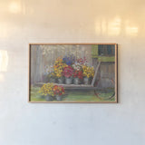 Garden Wheelbarrow by Carol Rowan. shown as a paper print in a natural frame. Available as a archival giclee rolled canvas, fine art paper, or poster print. SKU 41551i.