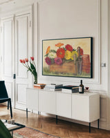 Gardeners Still Life with Gerberas by Carol Rowan. shown as a framed stretched canvas in a living room above a console. Available as a archival giclee rolled canvas, fine art paper, or poster print. SKU 42294i.