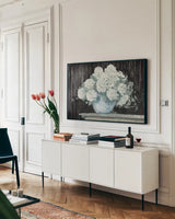 White Hydrangea on Black Crop by Carol Rowan. shown as a framed stretched canvas in a living room above a console. Available as a archival giclee rolled canvas, fine art paper, or poster print. SKU 50434i.