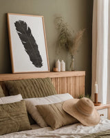 Black Feather V by Chris Paschke. shown as a paper print in a natural frame. Available as a archival giclee rolled canvas, fine art paper, or poster print. SKU 28001h.