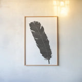 Black Feather V by Chris Paschke. shown as a paper print in a natural frame. Available as a archival giclee rolled canvas, fine art paper, or poster print. SKU 28001h.