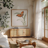 Butterfly Orange I by Chris Paschke. Shown in a natural wood frame in a cozy modern living room. Available as an archival giclee rolled canvas, fine art paper, or poster print. SKU 100068a.