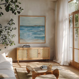 Coastal V by Chris Paschke. Shown in a natural wood frame in a cozy modern living room. Available as an archival giclee rolled canvas, fine art paper, or poster print. SKU 65771a.