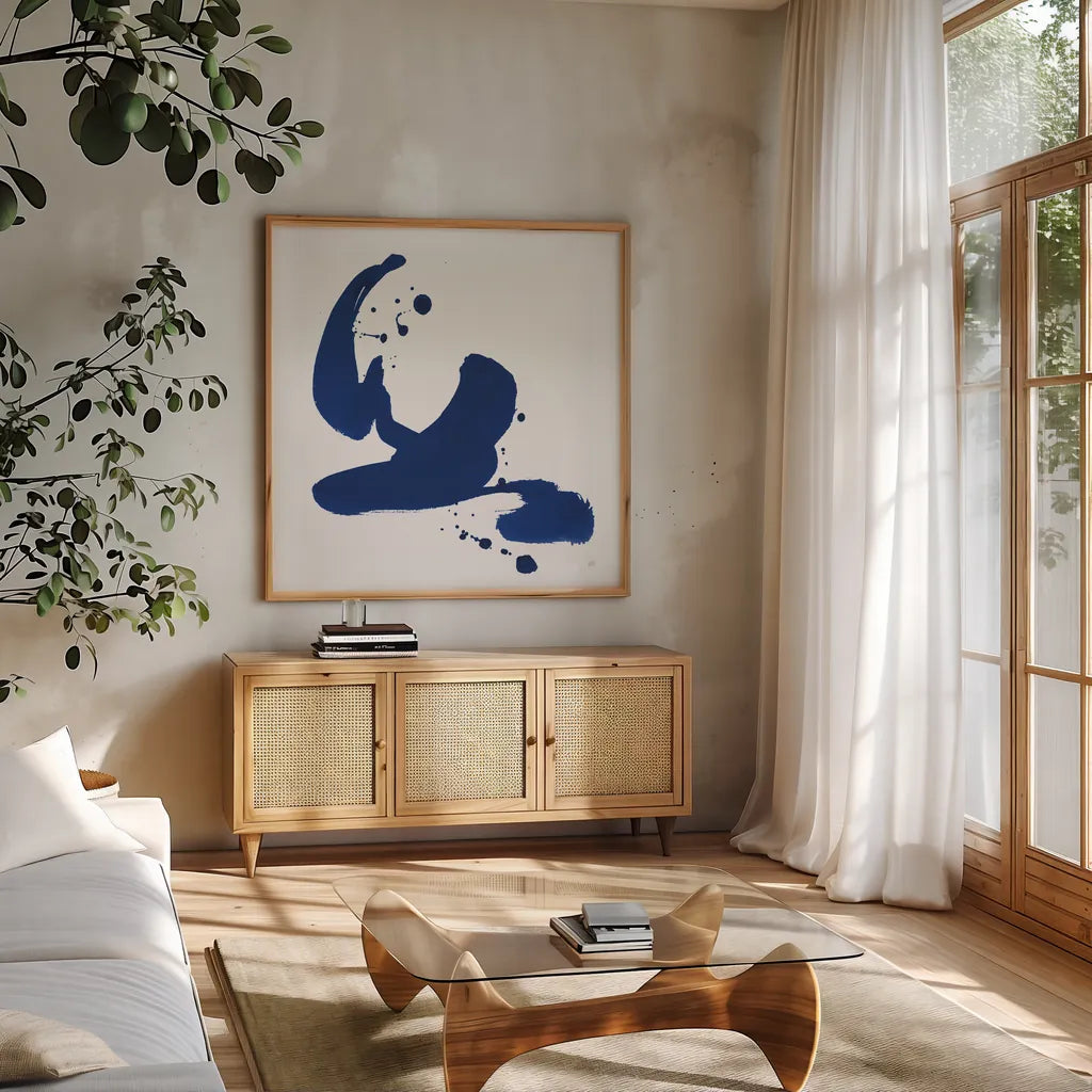 Cobalt Ink Drops I by Chris Paschke. Shown in a natural wood frame in a cozy modern living room. Available as an archival giclee rolled canvas, fine art paper, or poster print. SKU 67368a.