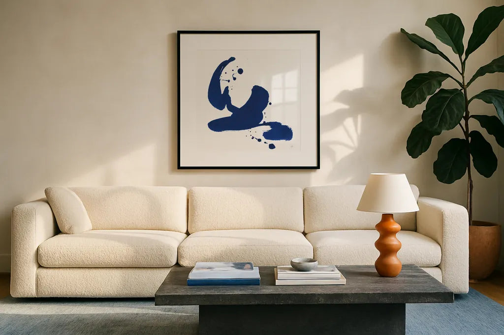 Cobalt Ink Drops I by Chris Paschke. Displayed in a glass frame with matte in a clean modern living room. Available as an archival giclee rolled canvas, fine art paper, or poster print. SKU 67368a.