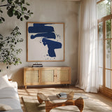 Cobalt Ink Drops IV by Chris Paschke. Shown in a natural wood frame in a cozy modern living room. Available as an archival giclee rolled canvas, fine art paper, or poster print. SKU 67371a.