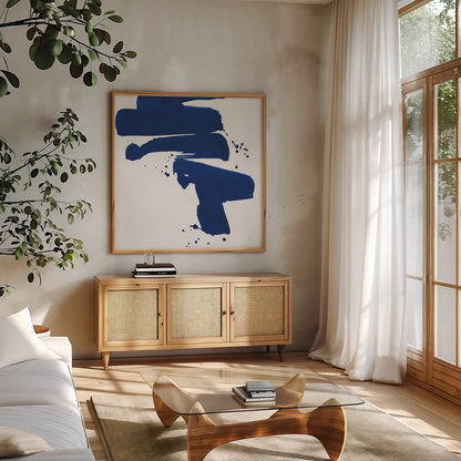 Cobalt Ink Drops IV by Chris Paschke. Shown in a natural wood frame in a cozy modern living room. Available as an archival giclee rolled canvas, fine art paper, or poster print. SKU 67371a.