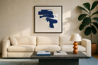 Cobalt Ink Drops IV by Chris Paschke. Displayed in a glass frame with matte in a clean modern living room. Available as an archival giclee rolled canvas, fine art paper, or poster print. SKU 67371a.