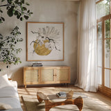 Delicate Gilded Vase I by Chris Paschke. Shown in a natural wood frame in a cozy modern living room. Available as an archival giclee rolled canvas, fine art paper, or poster print. SKU 74092a.