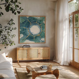 Dharma Wheel I by Chris Paschke. Shown in a natural wood frame in a cozy modern living room. Available as an archival giclee rolled canvas, fine art paper, or poster print. SKU 48026a.