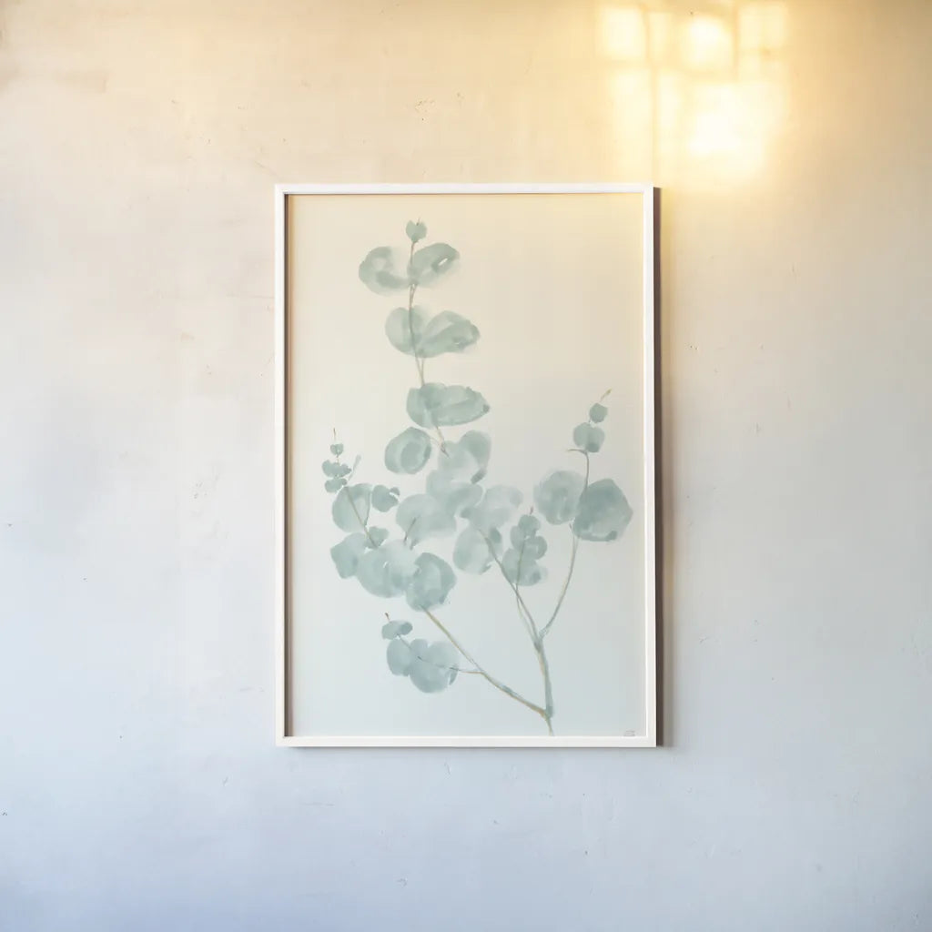 Eucalyptus Branch I by Chris Paschke. shown as a paper print in a white frame. Available as a archival giclee rolled canvas, fine art paper, or poster print. SKU 55063h.