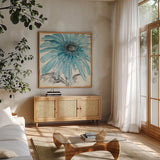 Gerbera Blue III by Chris Paschke. Shown in a natural wood frame in a cozy modern living room. Available as an archival giclee rolled canvas, fine art paper, or poster print. SKU 11092a.
