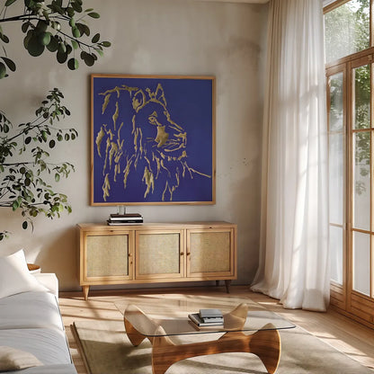 Gilded Lion Indigo by Chris Paschke. Shown in a natural wood frame in a cozy modern living room. Available as an archival giclee rolled canvas, fine art paper, or poster print. SKU 41917a.