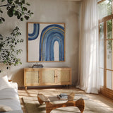 Gilded Rainbow I by Chris Paschke. Shown in a natural wood frame in a cozy modern living room. Available as an archival giclee rolled canvas, fine art paper, or poster print. SKU 68185a.