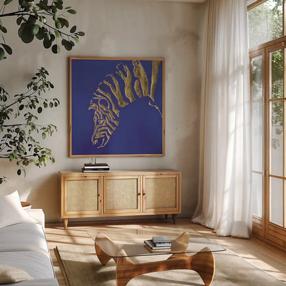 Gilded Zebra Indigo by Chris Paschke. Shown in a natural wood frame in a cozy modern living room. Available as an archival giclee rolled canvas, fine art paper, or poster print. SKU 41920a.